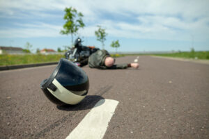 biker helmet lies on street near a motorcycle accident