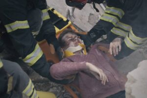 Emergency service workers pulling survivor from rubble