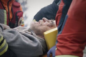 Paramedics carrying injured man after disaster